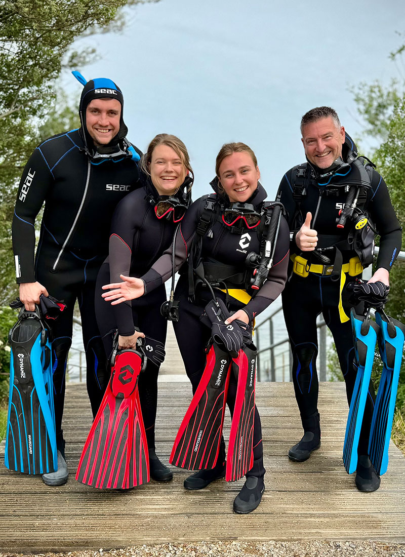 Lachende deelnemers in duikuitrusting